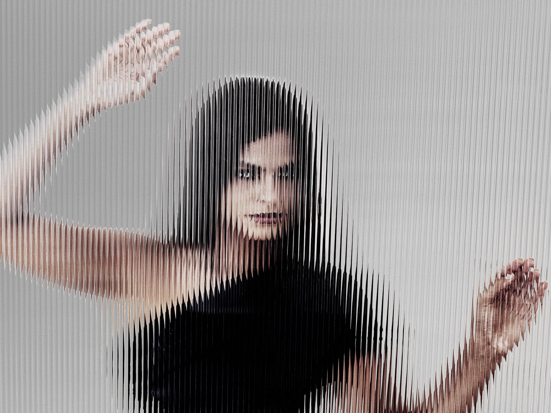 Portrait glimpsed through fluted glass, face and raised hand broken into vertical striped bands