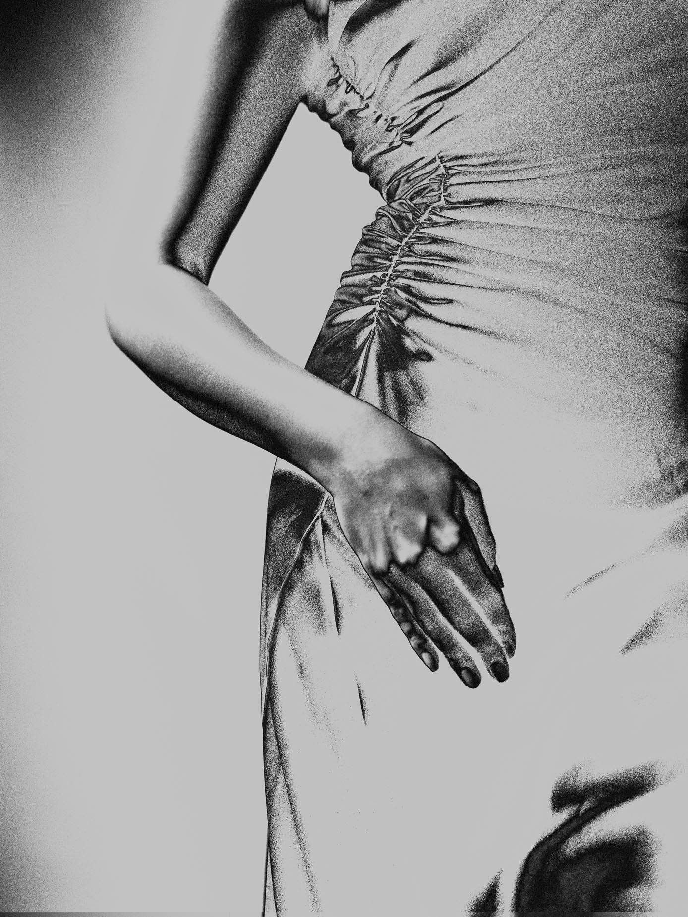 A hand rests against the ruched fabric of a dress, the arm bent at the elbow, grain and fabric texture rendered in fine detail