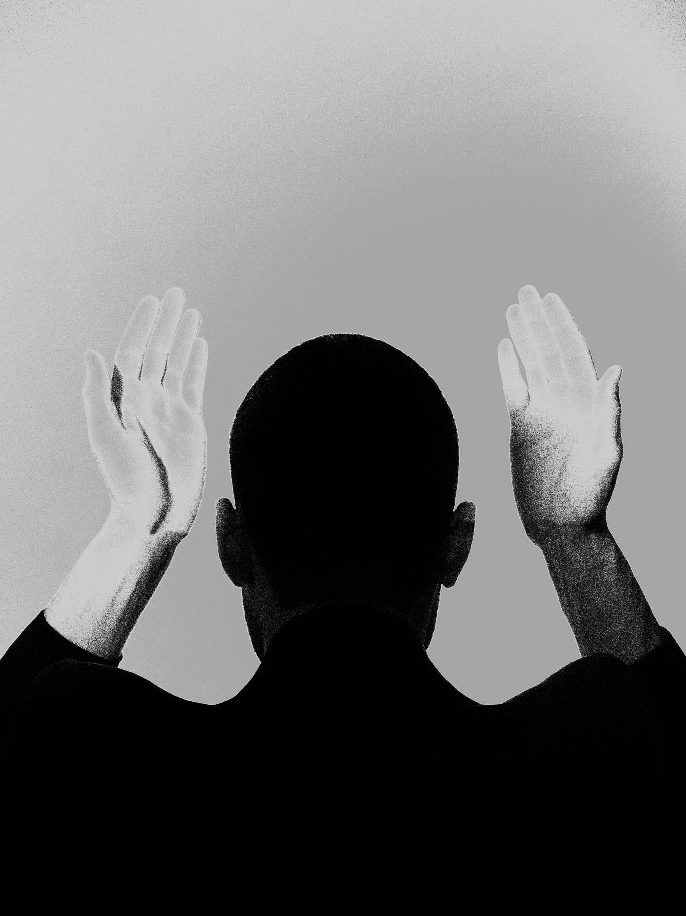 A bald figure seen from behind, both hands raised on either side of the head, palms open, silhouetted against a pale background